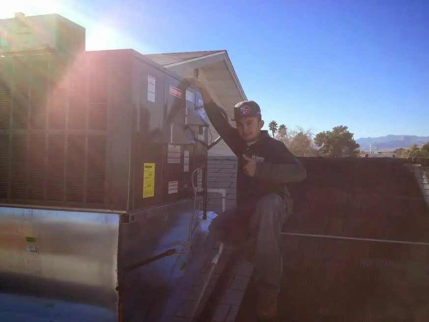 HVAC technician performing AC Tune-Up on a rooftop unit in Athens